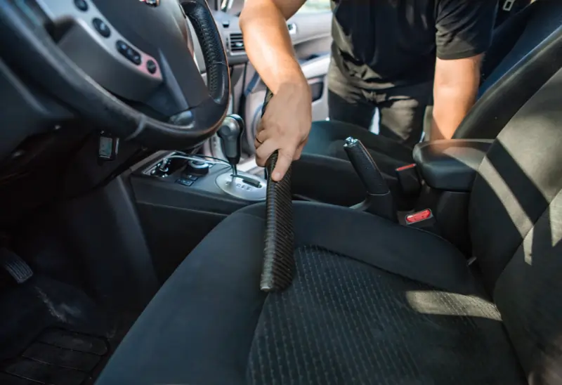 man vacuuming his car